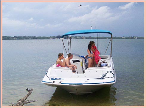 White boat with blue canopy on calm lagoon waters with guests aboard